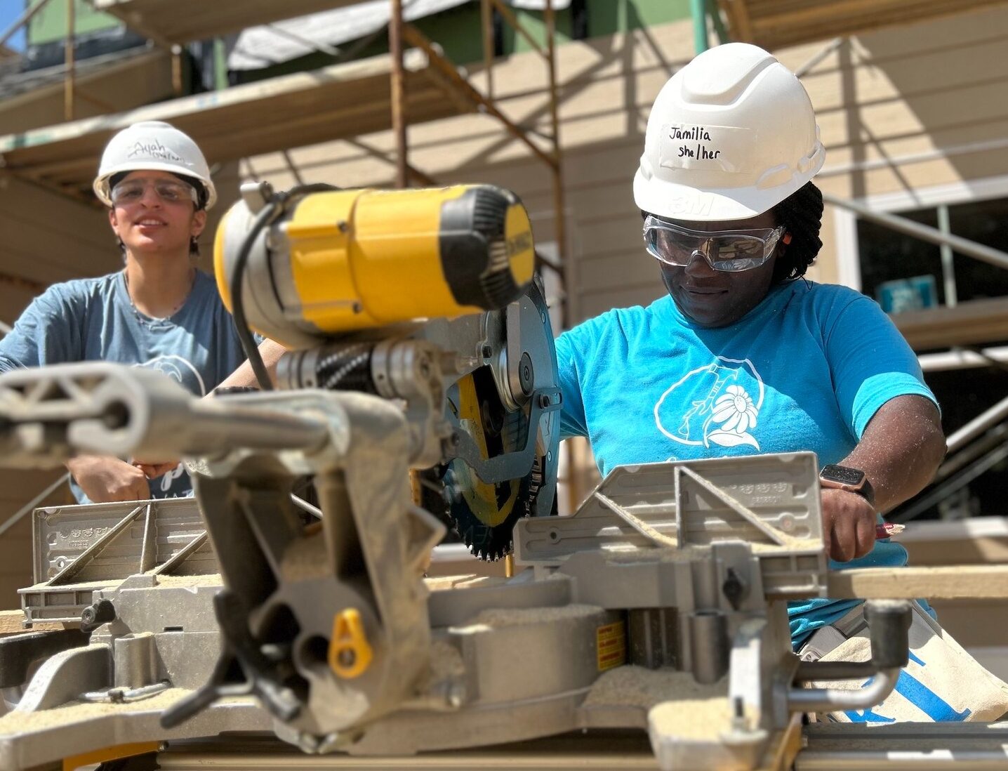 A trainee using a miter saw at the Hope Renovations workshop